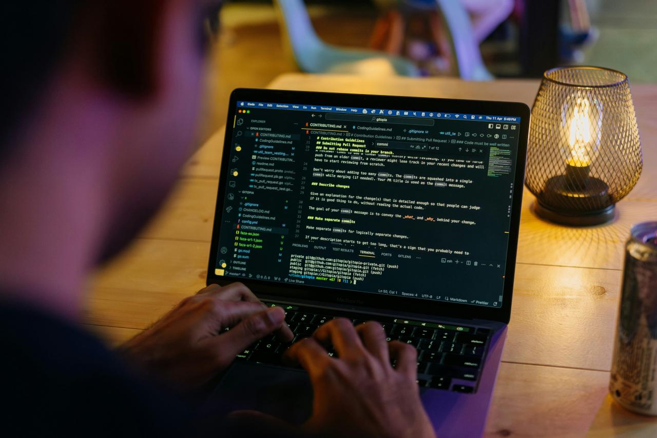 Seseorang duduk di meja dengan laptop